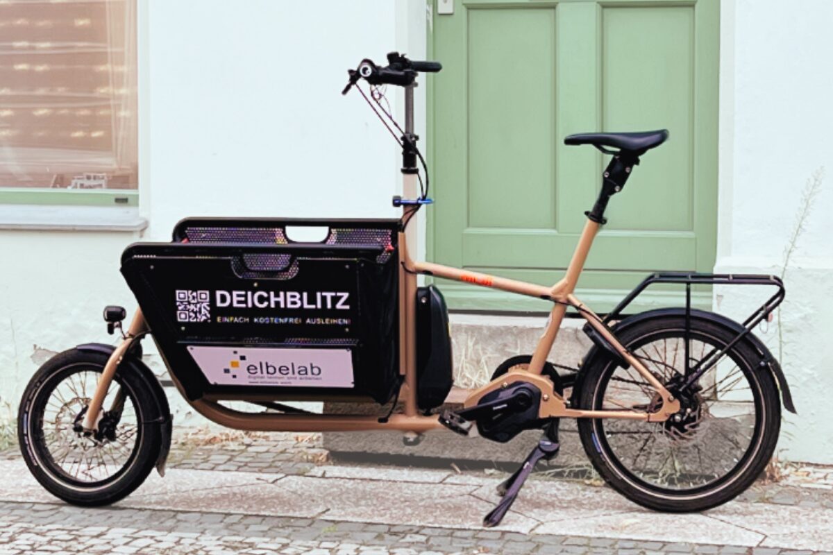 Ein Elektro-Lastenrad steht vor dem elbelab. Auf dem Fahrrad steht Deichblitz.
